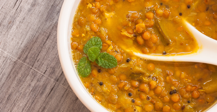 bowl of pumpkin lentil soup with spoon in it